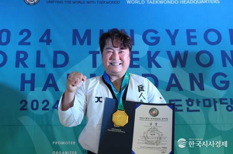 주먹격파 시니어 Ⅲ 우승자인 정상민 사범이 메달과 상장을 받은 뒤 주먹을 불끈쥐며 기념사진 촬영을 했다.