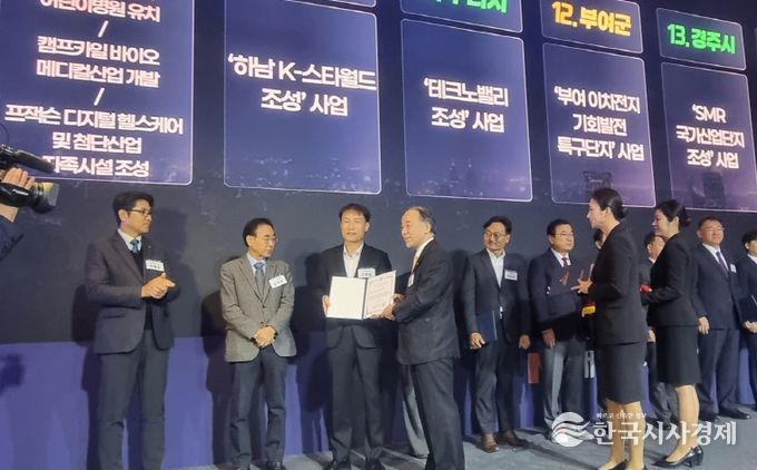 대한민국 100대 지역투자유망사업 선정 행사에서 경주시 관계자가 '경주 SMR국가산업단지 조성사업 선정 증서를 전달받고 있다