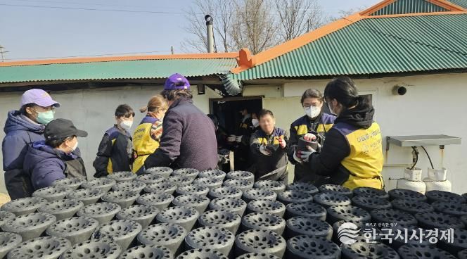 21일 봉사자들이 연탄을 트럭에 싣는 모습