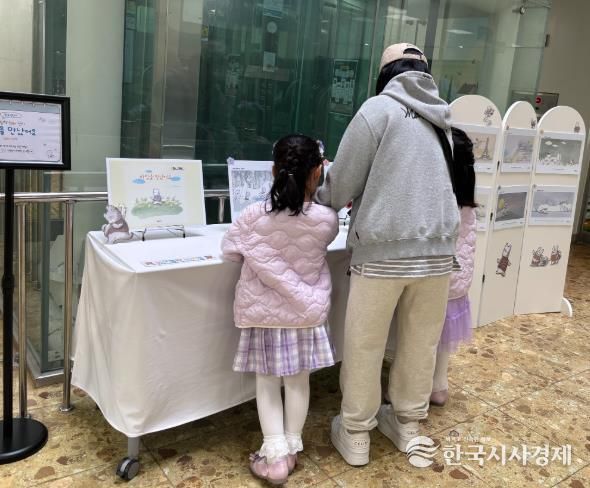 송정다가치문화도서관을 찾은 어린이와 시민들이 지난 3월 28일 도서관 1층 로비에 마련된 ‘열린 시선과 새로운 만남’ 그림책 원화 전시를 관람하고 있다.