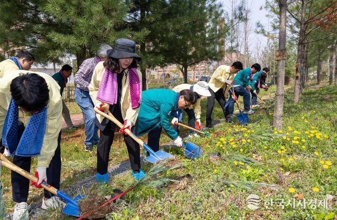 세종시교육청은 교육청 내 정원에서 2026년 식목일 기념 청사 가꾸기 행사를 진행하고 있다. 사진은 세종시교육청 직원들이 직접 나무를 심고 코코넛 껍질 조각을 채우는 모습
